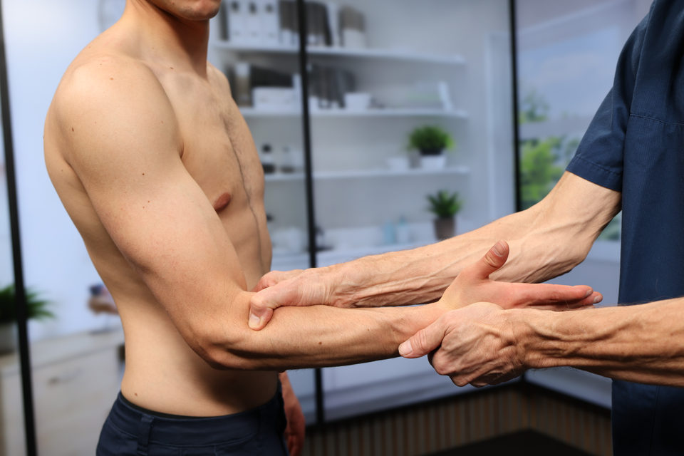Undersøkeren palperer radiushodet ved albuen mens underarmen støttes.